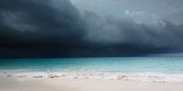 Advancing storm with dark clouds over tropical beach