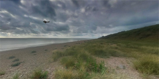 WWII fighter plane flying over North Sea at Suffolk beach