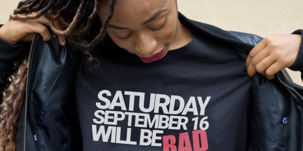 Woman taking off coat with t-shirt stating: Saturday September 16 Will Be BAD