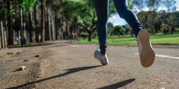 Woman jogging, only legs visible.