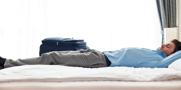 Man lying on bed in a hotel room.