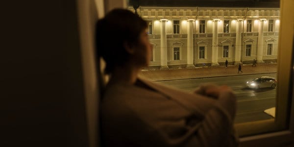 Woman staring out of window at night.