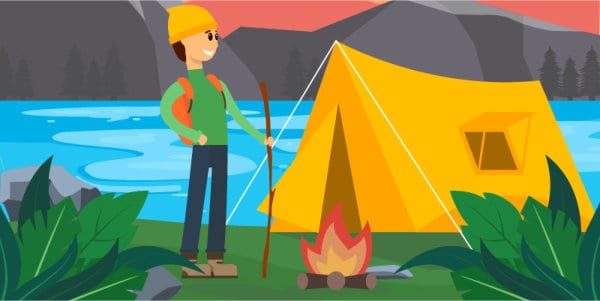 Camper standing beside tent and campfire.