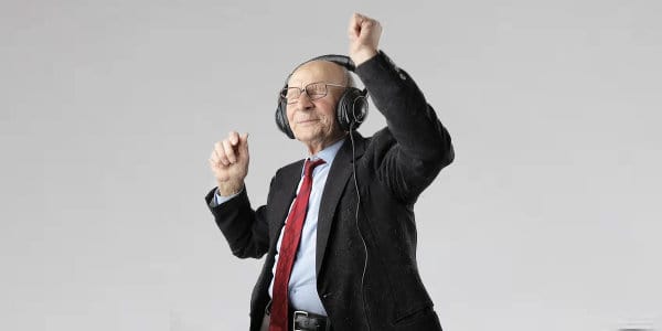 Old man wearing headphones dancing with eyes closed