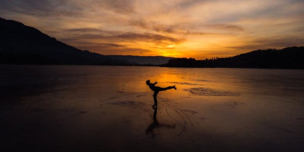 Figure skating on frozen lake at sun down