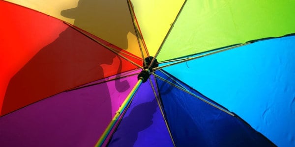 Detective shadow on rainbow coloured umbrella