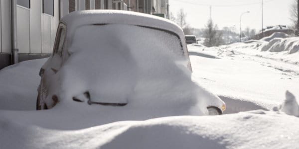 Car and street coverd in snow,