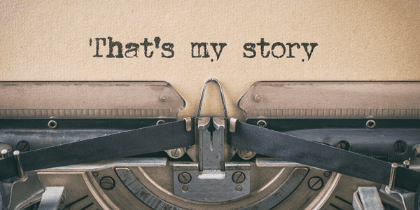 Type writer and a sheet of paper with the line "that's my story" on it