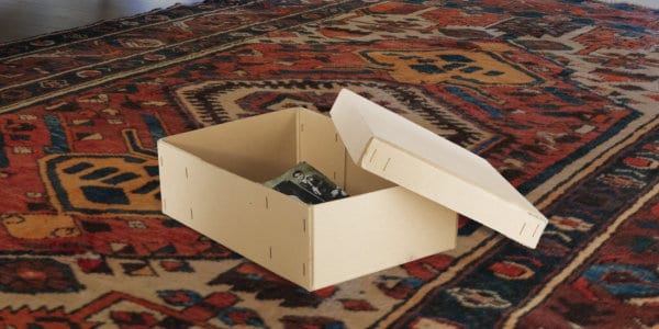 Open shoebox with old pictures inside, on Persian carpet