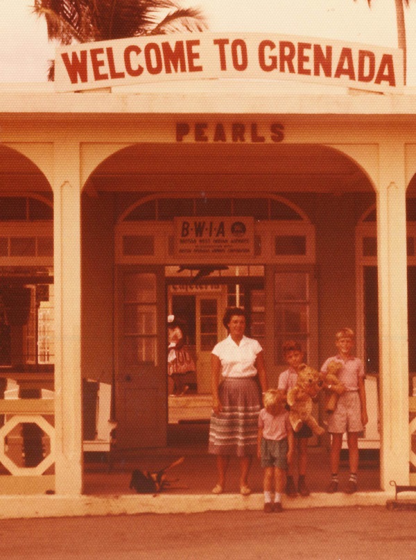 A Young Peter Scotchmer with his two brothers and his mum at Pearls Airport in Grenada in 1961. An overhead sign says "Welcome To Grenada".