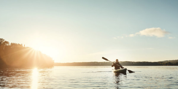 Man canoeing on a lake in the morning