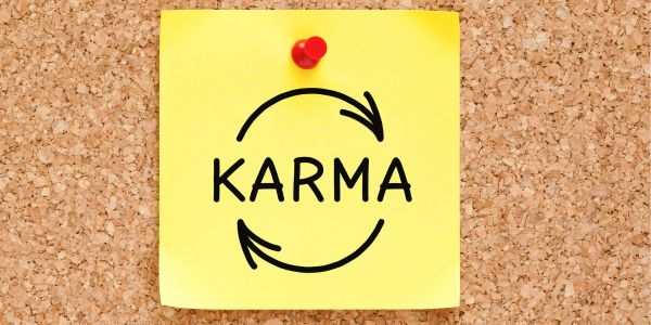 A post-it note with "karma" written on it, and two arrows around it, making a circle.