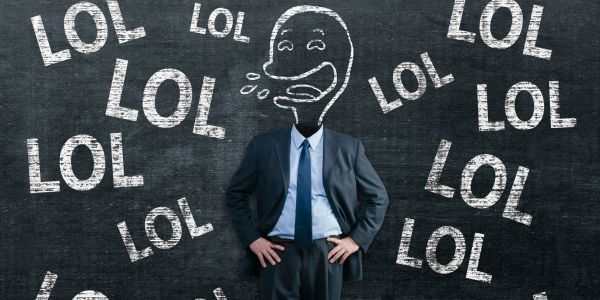 Man in front of a chalkboard with several times LOL on it.