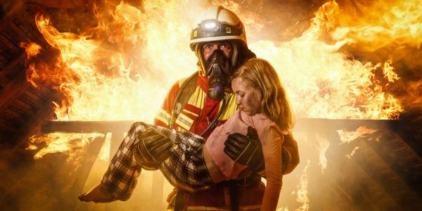 Hero Fireman carrying out a girl with a blaze in the background