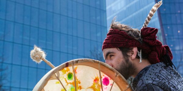 Man holding native drum downtown